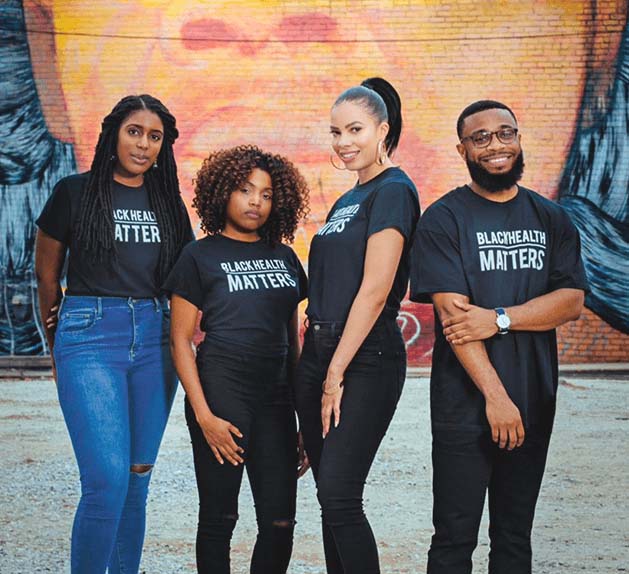 4 individuals standing in front of a mural with Black Health Matters shirts